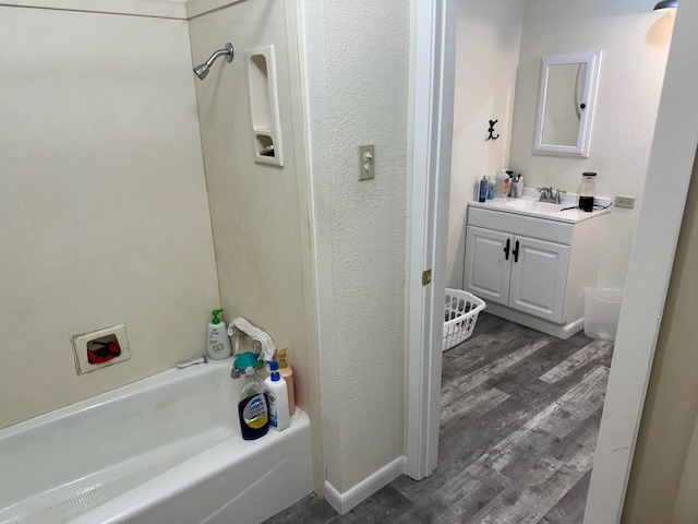 bathroom featuring hardwood / wood-style flooring, vanity, and shower / bathing tub combination