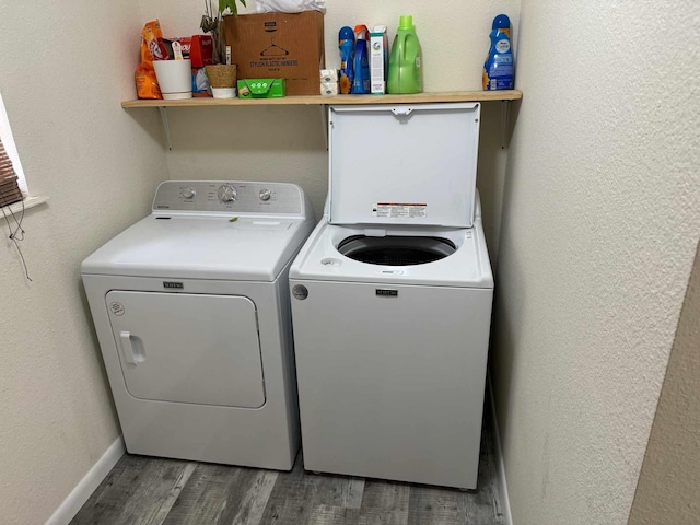 laundry area featuring washing machine and dryer and hardwood / wood-style flooring