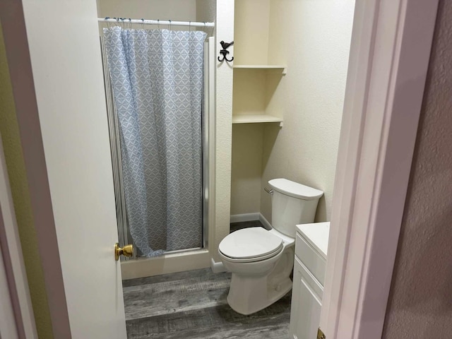 bathroom featuring vanity, hardwood / wood-style flooring, toilet, and curtained shower