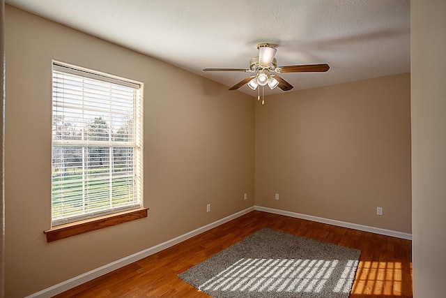 empty room with hardwood / wood-style flooring and ceiling fan