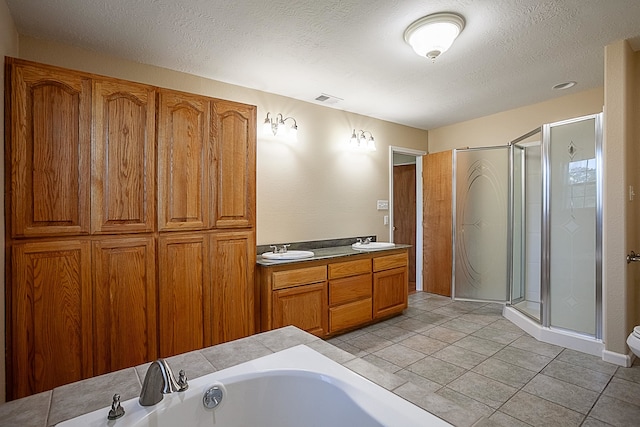 bathroom featuring a textured ceiling, vanity, shower with separate bathtub, and tile patterned floors