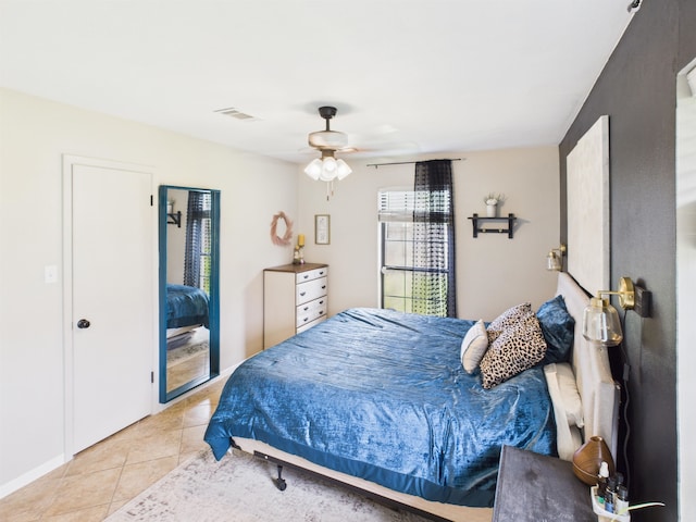 bedroom featuring light tile patterned floors, visible vents, and ceiling fan