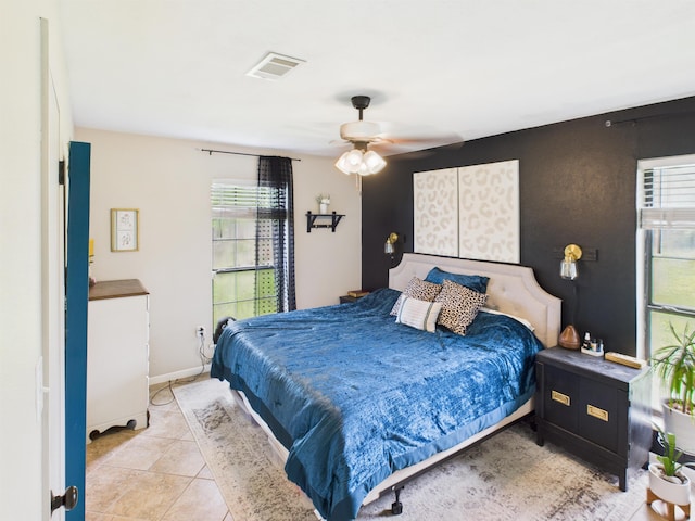 bedroom featuring baseboards, visible vents, a ceiling fan, and light tile patterned flooring
