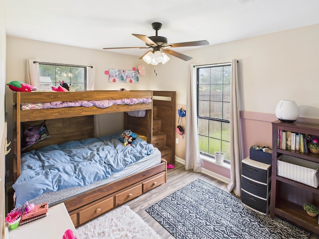 bedroom with wood finished floors, a ceiling fan, and baseboards