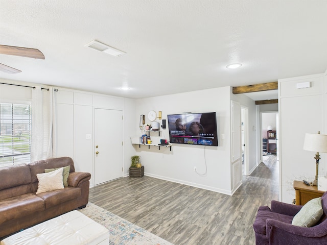 living room with baseboards, visible vents, and wood finished floors
