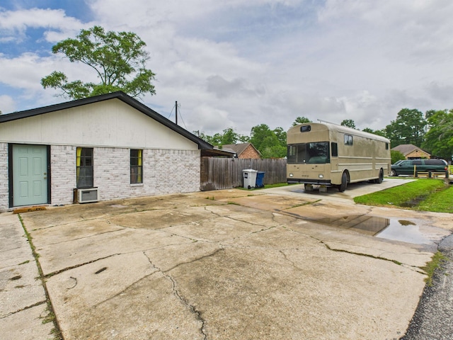 view of home's exterior featuring fence and brick siding
