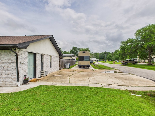view of yard with fence and concrete driveway