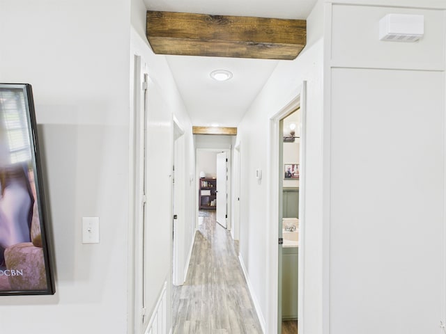 corridor with baseboards and light wood-style floors