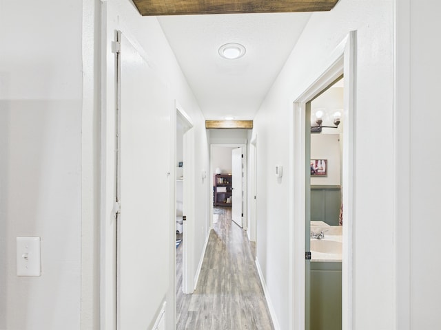 hallway with baseboards and light wood-style floors