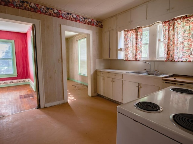 kitchen featuring white cabinetry, sink, and range