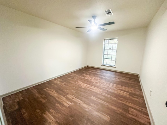 spare room featuring a ceiling fan, wood finished floors, visible vents, and baseboards