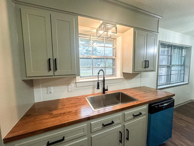 kitchen with crown molding, butcher block counters, a sink, a textured ceiling, and dishwasher