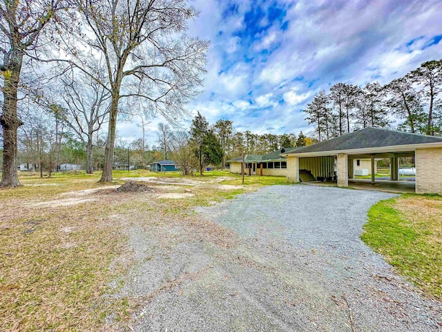 view of front of house featuring gravel driveway and brick siding