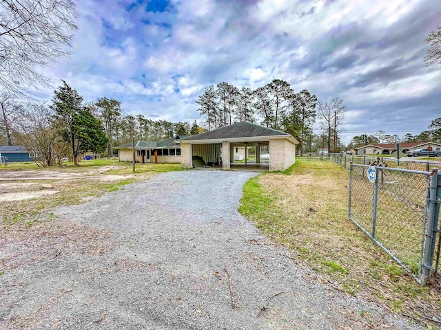 bungalow featuring gravel driveway and fence