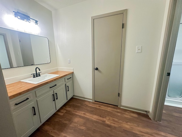 bathroom with wood finished floors and vanity