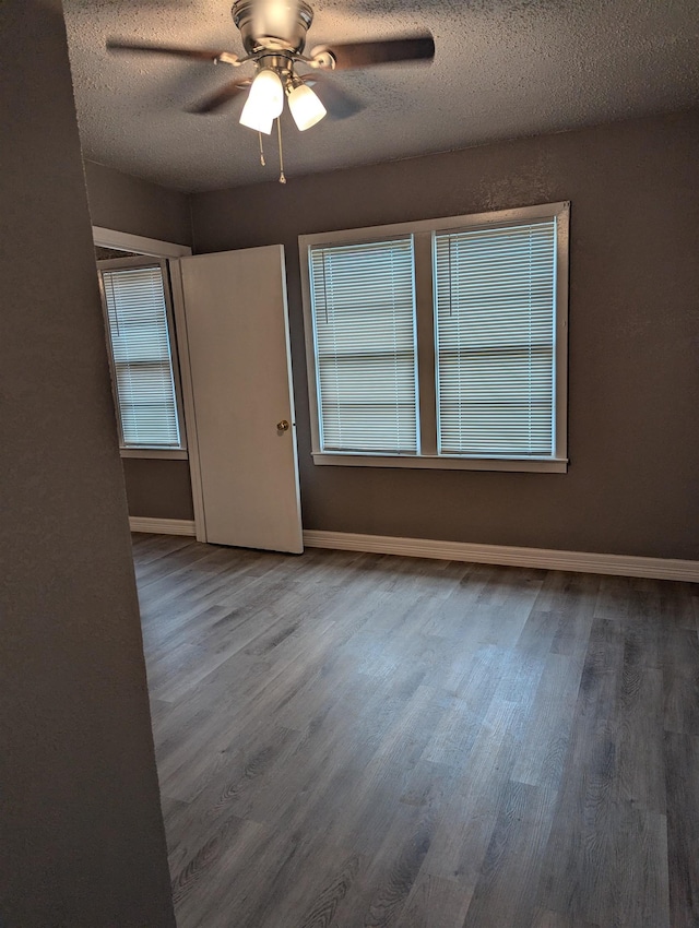 unfurnished room with hardwood / wood-style floors, ceiling fan, and a textured ceiling