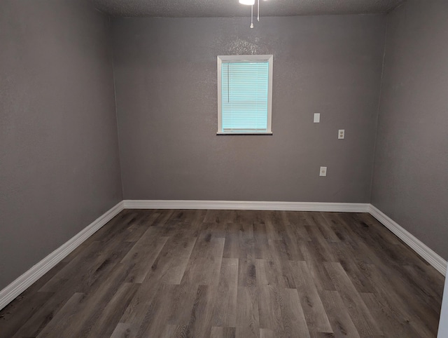 empty room with wood-type flooring and a textured ceiling