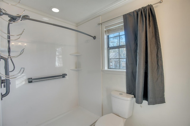 bathroom featuring toilet, a shower, and ornamental molding