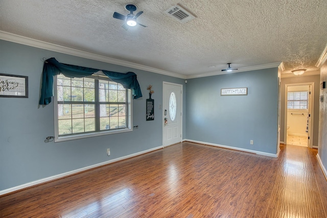 spare room with hardwood / wood-style flooring, ceiling fan, ornamental molding, and a textured ceiling