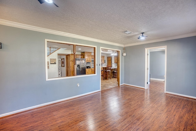 spare room with hardwood / wood-style floors, ceiling fan, ornamental molding, and a textured ceiling