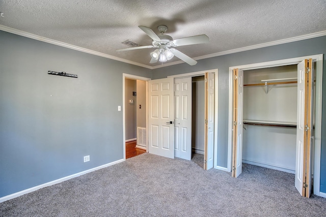 unfurnished bedroom featuring a textured ceiling, carpet floors, ceiling fan, and crown molding