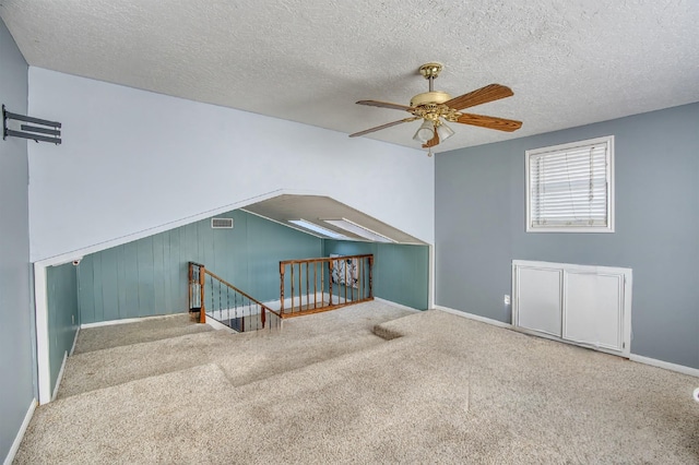 additional living space featuring carpet flooring, ceiling fan, and a textured ceiling