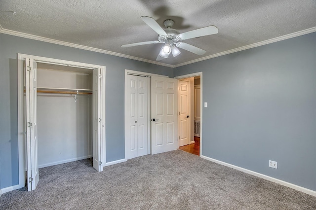 unfurnished bedroom with carpet, two closets, ceiling fan, and ornamental molding