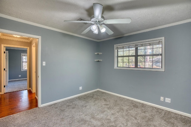 carpeted spare room with a textured ceiling, ceiling fan, and crown molding