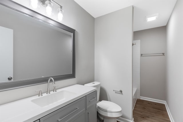 full bathroom featuring hardwood / wood-style floors, vanity, bathtub / shower combination, and toilet