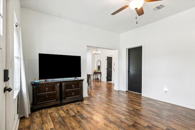 living room featuring ceiling fan with notable chandelier and dark hardwood / wood-style floors