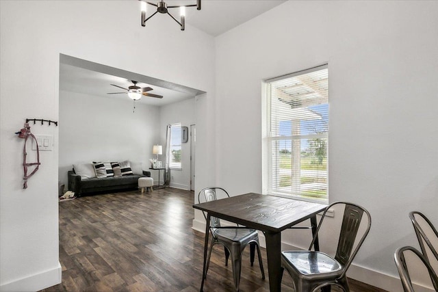 dining area featuring ceiling fan with notable chandelier and dark hardwood / wood-style floors