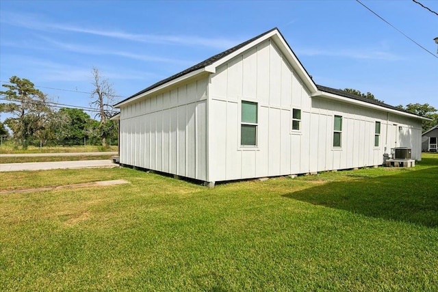 view of property exterior with central air condition unit and a lawn