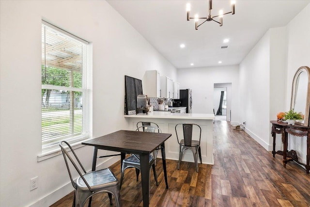 dining space with plenty of natural light, dark hardwood / wood-style floors, and a chandelier