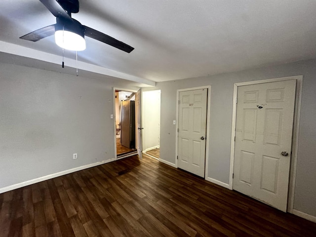 unfurnished bedroom with multiple closets, ceiling fan, and dark hardwood / wood-style flooring