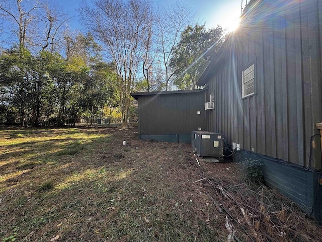 view of property exterior with a yard and central air condition unit