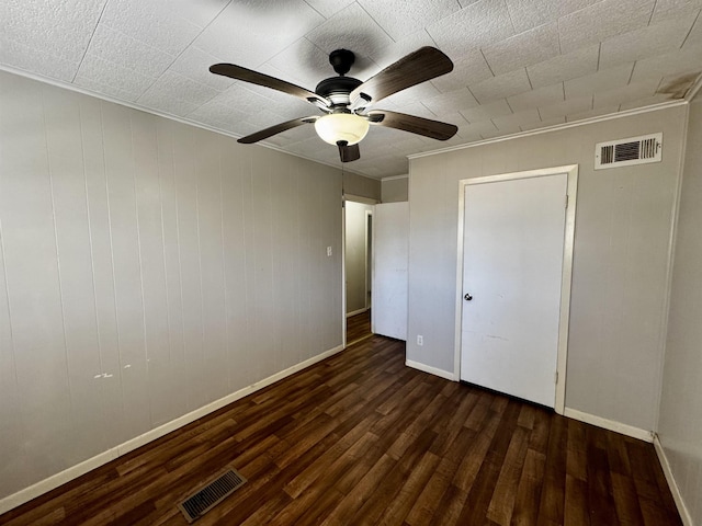 unfurnished bedroom with dark hardwood / wood-style flooring, crown molding, and ceiling fan