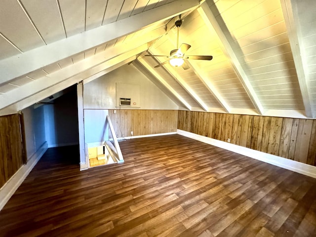 additional living space with vaulted ceiling with beams, dark wood-type flooring, ceiling fan, and wood walls