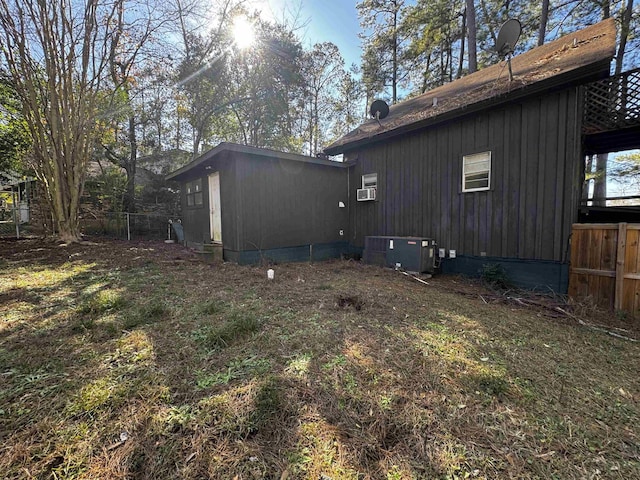 view of side of home featuring central AC and a lawn