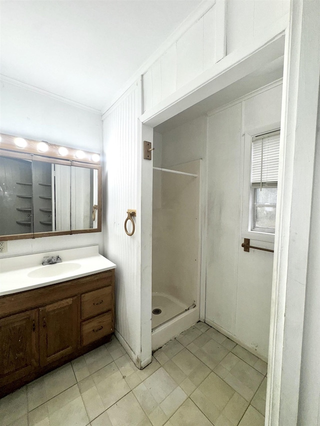 bathroom with walk in shower, ornamental molding, and vanity