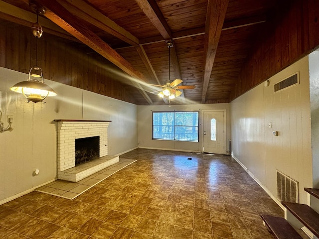 unfurnished living room featuring beamed ceiling, ceiling fan, wood ceiling, and a fireplace