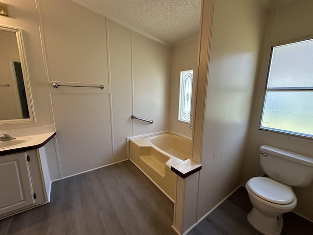 bathroom with a textured ceiling, a tub, hardwood / wood-style floors, and plenty of natural light