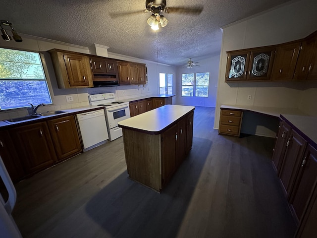 kitchen with dark brown cabinets, white appliances, a textured ceiling, sink, and a kitchen island