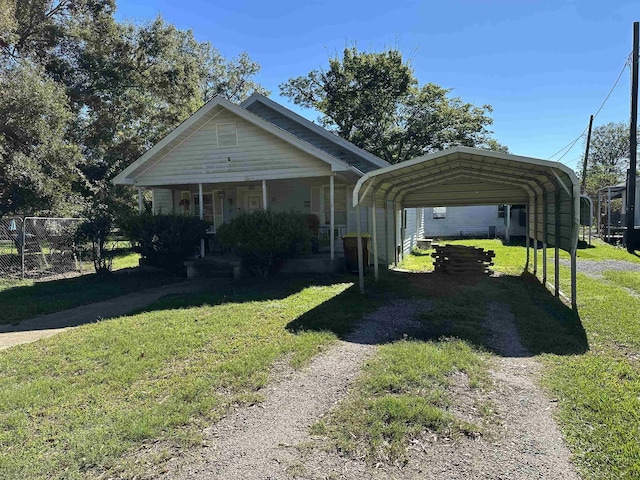 view of front facade with a carport, covered porch, and a front lawn