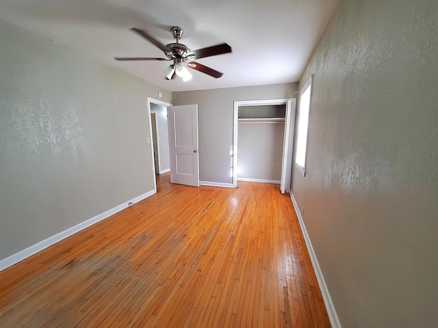 unfurnished bedroom featuring ceiling fan, a closet, and light hardwood / wood-style flooring