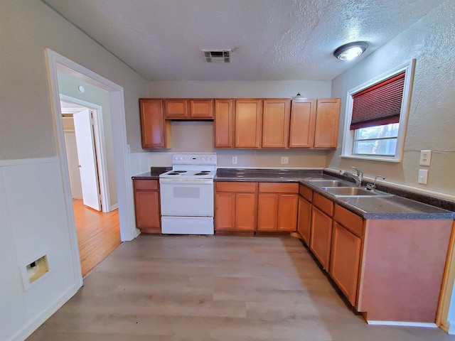 kitchen featuring a textured ceiling, light hardwood / wood-style floors, white electric range, and sink