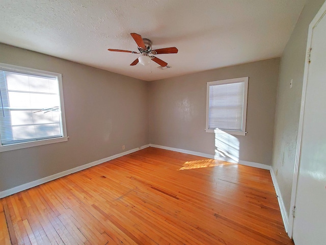 unfurnished room with ceiling fan, light wood-type flooring, and a textured ceiling