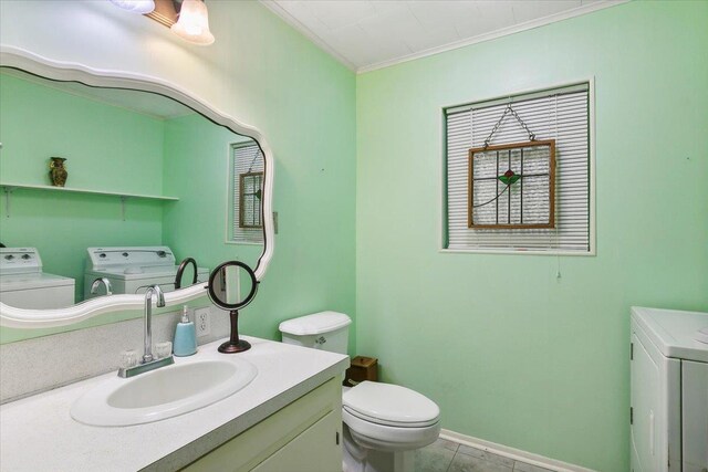 bathroom featuring washing machine and clothes dryer, tile patterned flooring, crown molding, toilet, and vanity