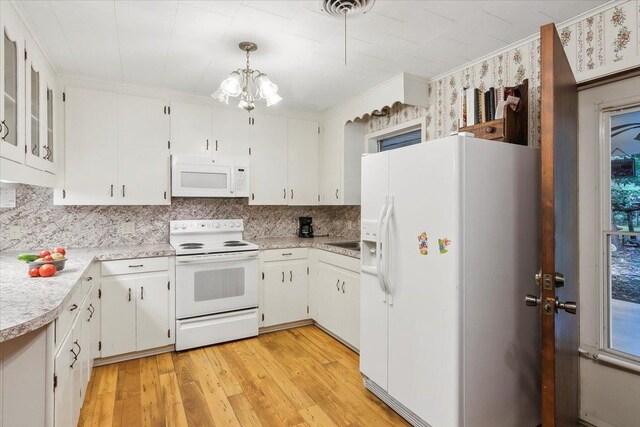 kitchen with white cabinetry, light hardwood / wood-style flooring, decorative light fixtures, and white appliances