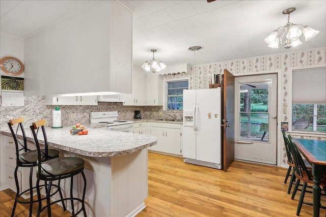 kitchen featuring white cabinetry, sink, white appliances, and an inviting chandelier