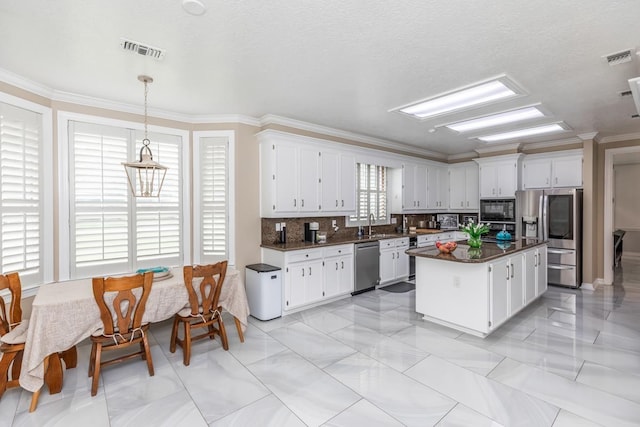 kitchen with visible vents, crown molding, dark countertops, tasteful backsplash, and appliances with stainless steel finishes